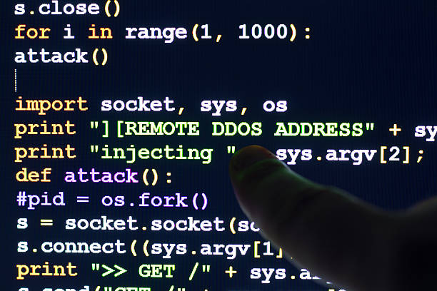 Палец указывает на экран компьютера, на котором отображается код на Python, связанный с DDoS-атакой.